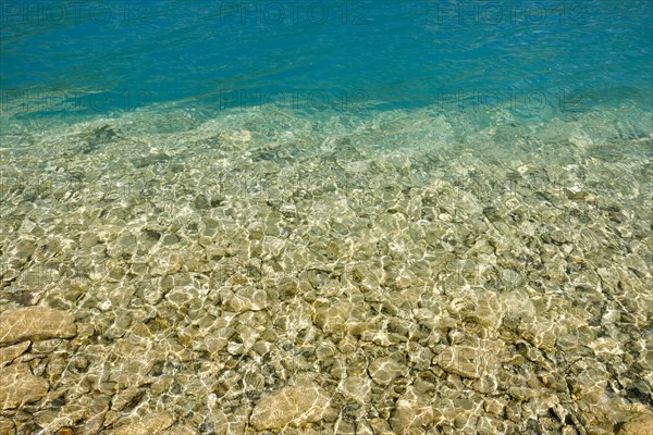 Fascinating play of colours and shapes of the clear water of Lake Walen at the edge of the shore