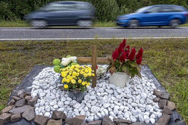 Memorial with cross for victims of road accident on country road