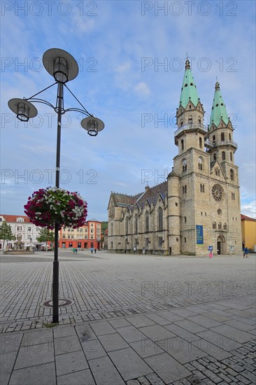 Gothic town church with twin towers on the market square with street lamp and floral decoration