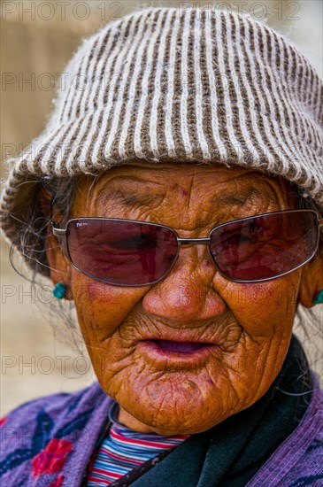 Old woman walking through a temple in the kingdom of Guge