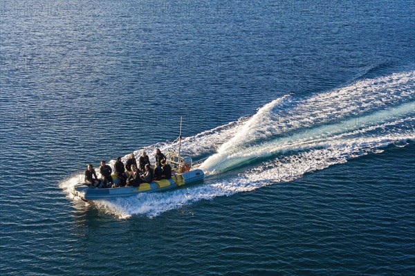 Bird's eye view of diving boat inflatable boat in fast motion with scuba diver on board