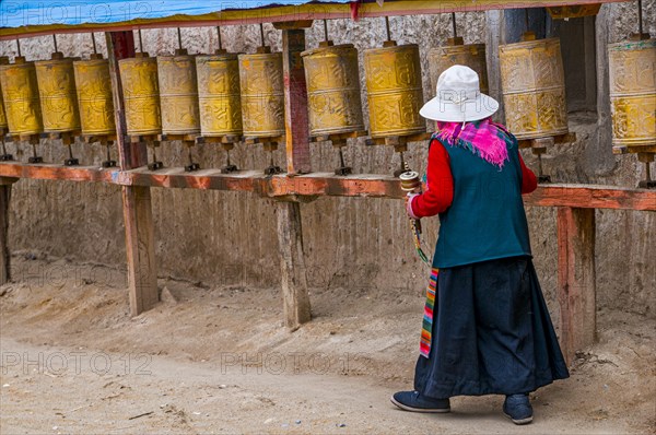 Old woman turning the prayer wheels in the kingdom of Guge