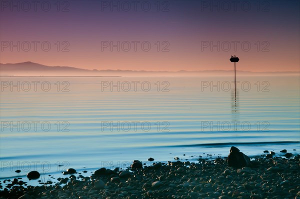 Sea mark at sunset on Lake Constance near Lochau