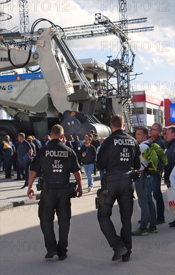 Two police officers help and advise at the trade fair grounds