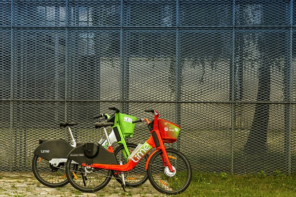 Lime rental bikes in front of high mesh fence