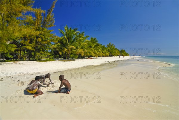 Children playing on a white sand beach on Iles aux Nattes near Ile saint marie