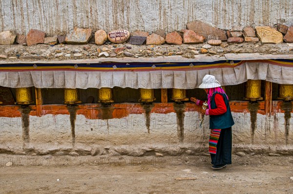 Old woman turning the prayer wheels in the kingdom of Guge