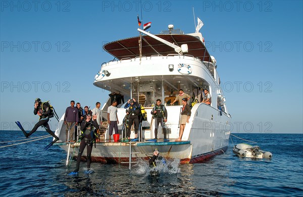 Divers jump from dive deck of dive ship for dive cruise into sea water