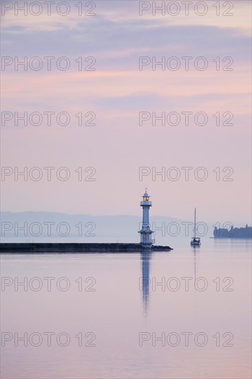 Lighthouse by the harbour wall at the Lake Geneva basin at pink dawn