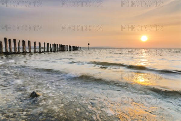 Golden sunrise on the shore of Lake Constance with jetty near Altnau in the canton of Thurgau