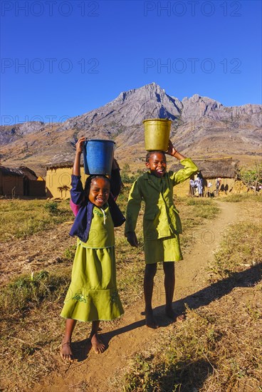 Girls with water buckets on a head
