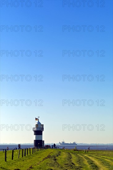 Wremertief in the district of Cuxhaven. Kleiner Preusse lighthouse and freighter on the Aussenweser