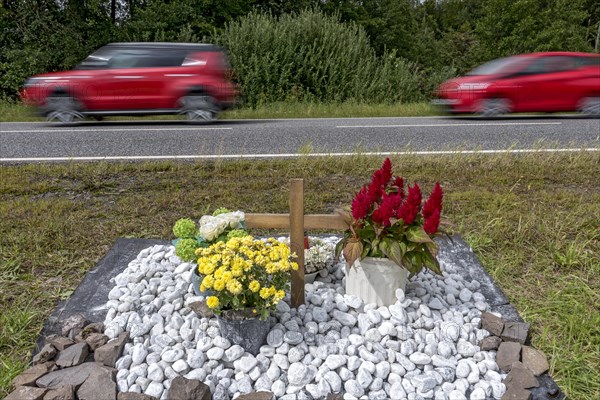 Memorial with cross for victims of road accident on country road