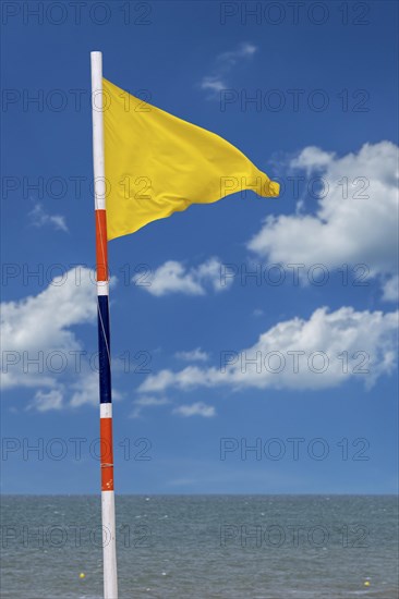 Yellow warning flag signalling medium hazard. Swimming allowed