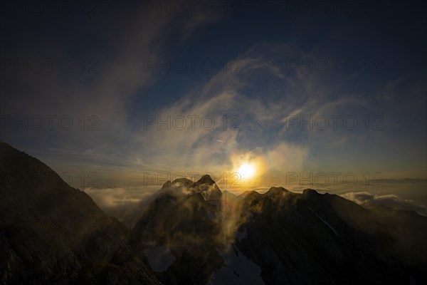 Altmann summit with yellow cloud wisps at sunrise