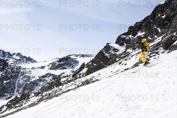 Ski tourers descending a steep slope