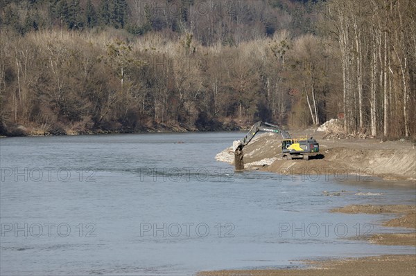 An excavator reshapes the banks of a river