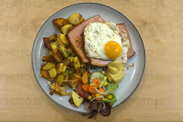 Leberkaes with fried egg and fried potatoes