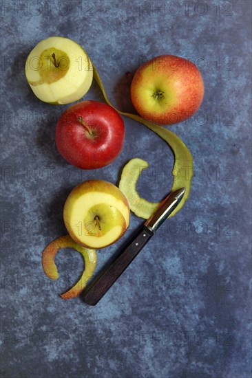 Peeled apples with peeling knife