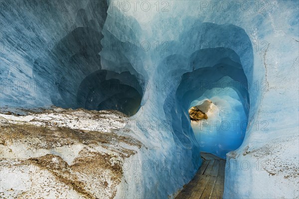 Visitors Wooden footbridge through ice tunnel in the Rhone glacier