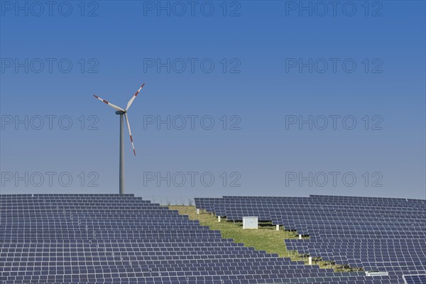 Solar plant with wind turbine in the background