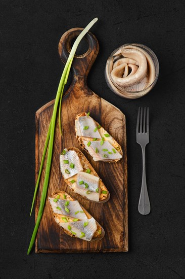 Top view of sandwich with salty herring and spring onion