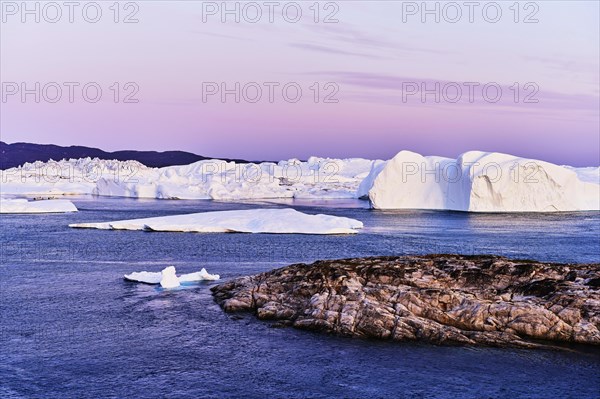 Gigantic icebergs in the light of the blue hour