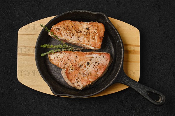 Top view of roasted tuna steak in cast iron pan