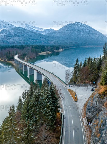 Road with bridge on the water in winter