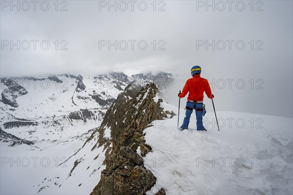 Ski tourers on rocky ridge with snow