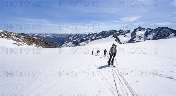 Ski tourers walking on the rope on the glacier