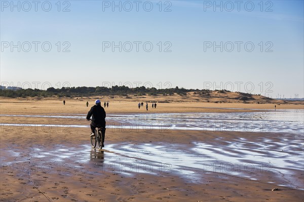 Local cyclist and walker on the beach
