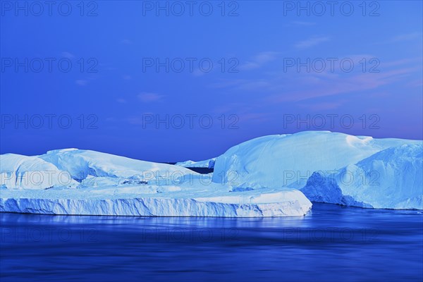 Gigantic icebergs in the light of the blue hour