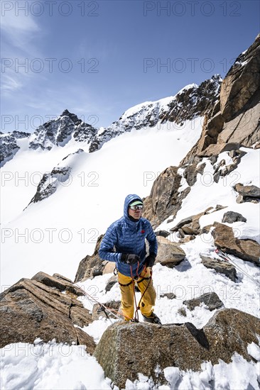 Ski tourers preparing rope belay for descent on the rope