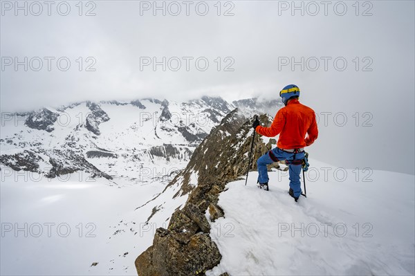 Ski tourers on rocky ridge with snow