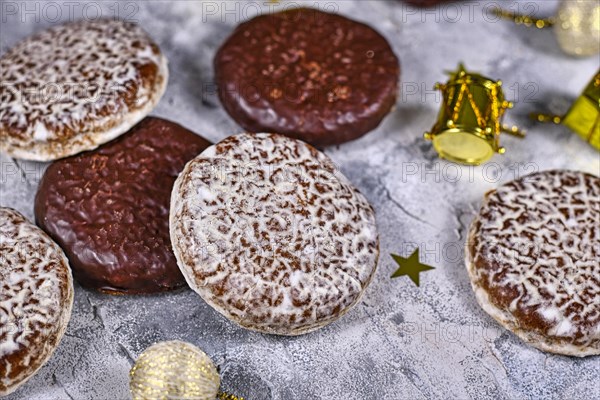 German round gingerbread called Lebkuchen with white and chocolate glazing surrounded by seasonal Christmas decoration