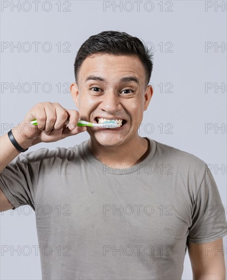 Face of handsome man brushing his teeth. Tooth brushing and care concept. Face of guy brushing teeth isolated. Oral and dental smile concept