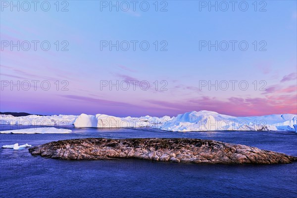 Gigantic icebergs in the light of the blue hour