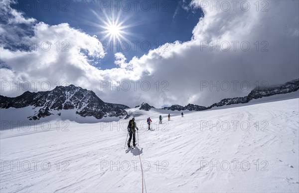 Group of ski tourers ascending on the rope