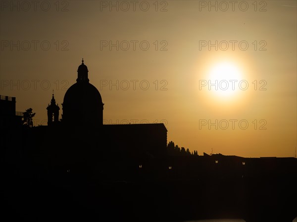 The silhouette of the Basilica di Santa Maria del Carmine against the light at sunset