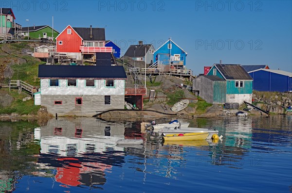 Colourful houses reflected in the water of a fjord