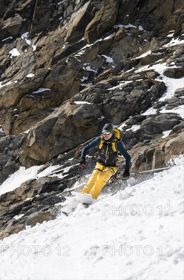 Ski tourers descending a steep slope