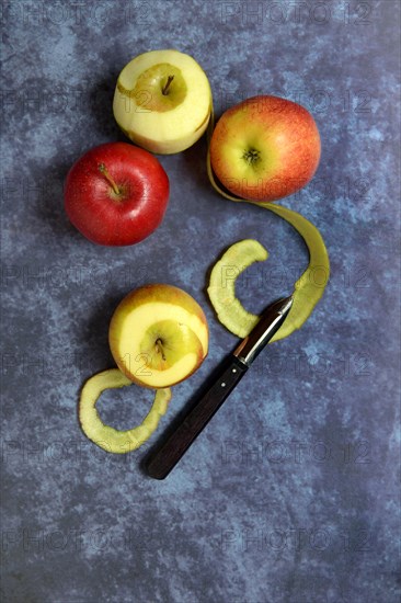 Peeled apples with peeling knife