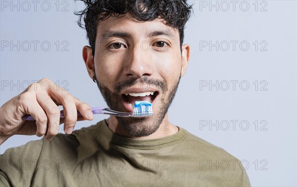Close up of man brushing his teeth isolated