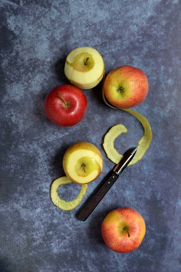 Peeled apples with peeling knife