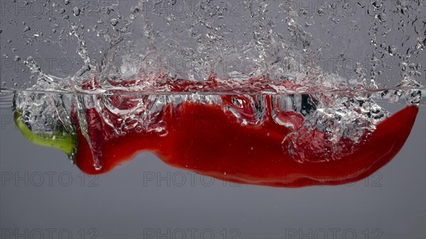 A red pepper splashes into the water and creates a whirlpool