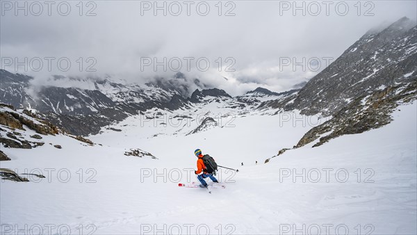 Skiers skiing downhill on the Sommerwandferner glacier