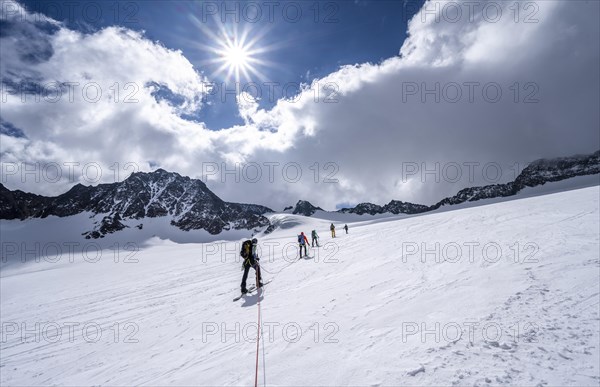 Group of ski tourers ascending on the rope