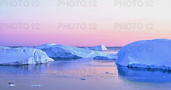 Gigantic icebergs in the light of the blue hour