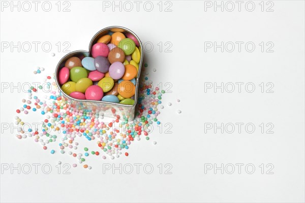 Chocolate lentils and love beads in heart-shaped cookie cutter